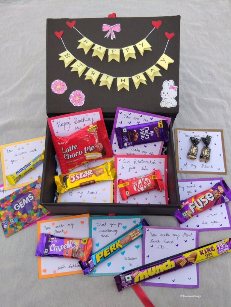 Black birthday gift box filled with assorted chocolates and personalized handwritten notes.