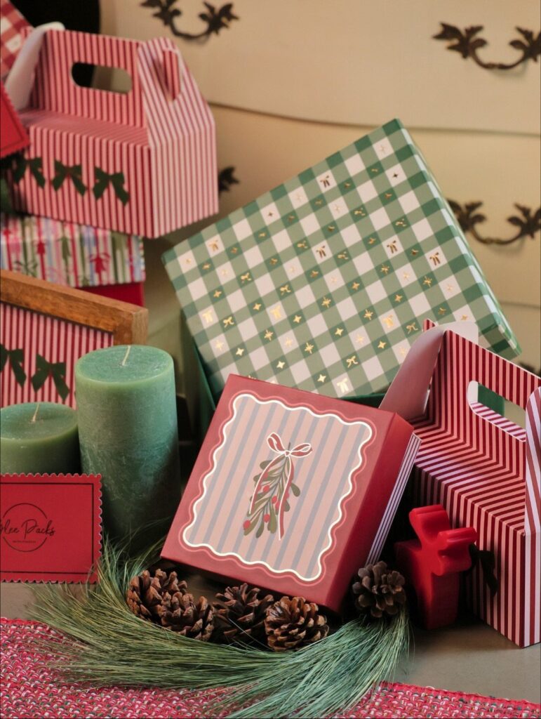 Christmas gift boxes in red and green patterns with candles and pinecones
