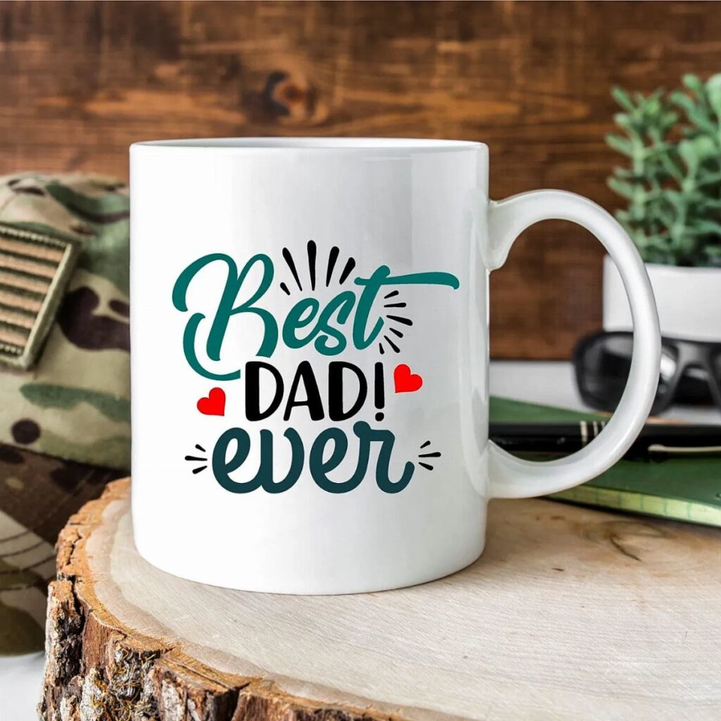 White ceramic mug with Best Dad Ever text on a wooden slice.