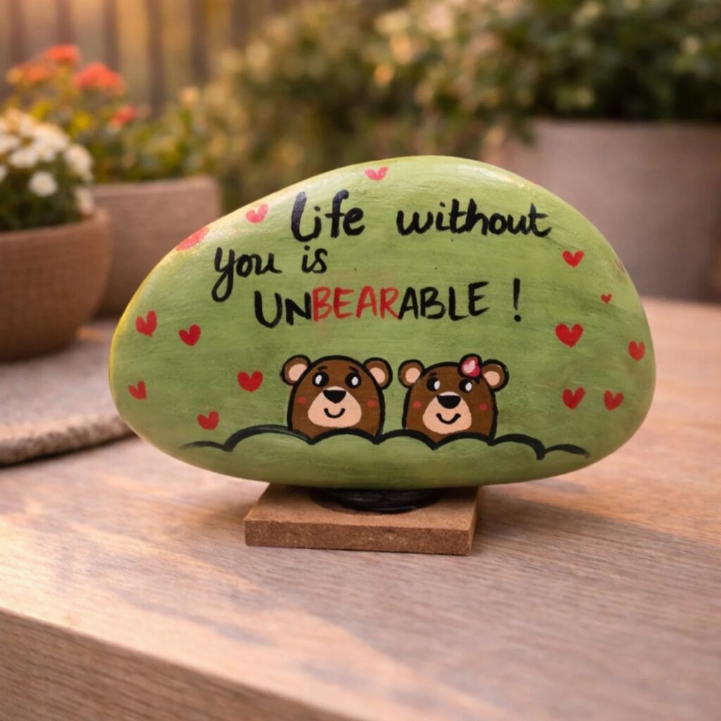 Green painted rock with two bears and a romantic pun for Valentine's Day.