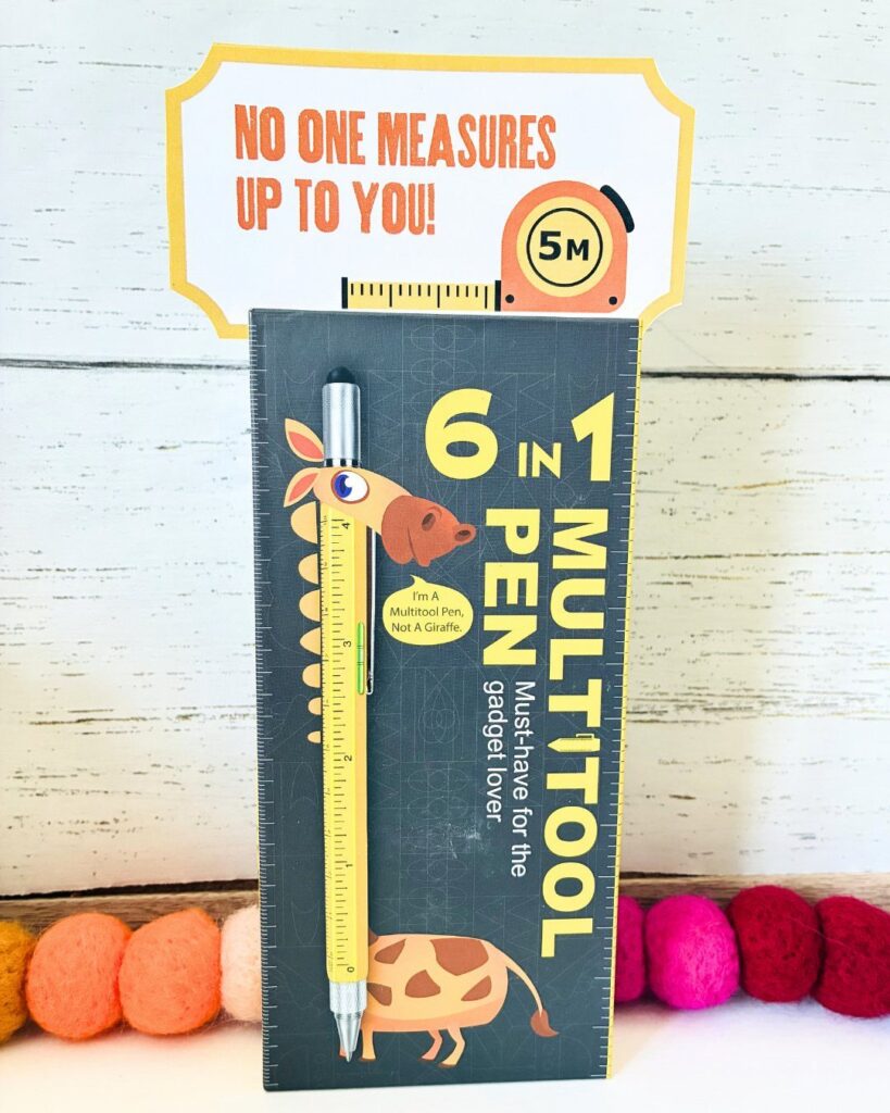 Multi-tool pen on packaging with a yellow teacher gift tag and punny text.