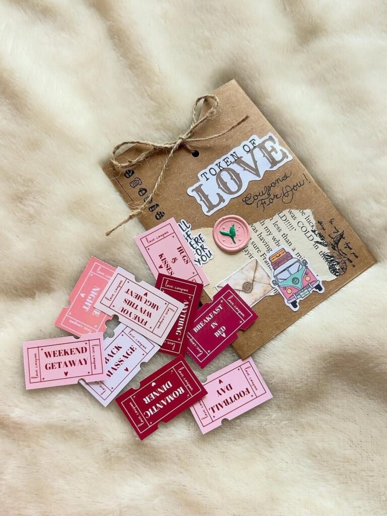Handmade love coupons in pink and red spilling from a brown kraft envelope.